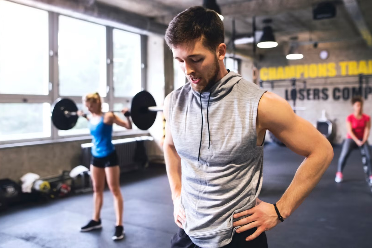 hombre tomando un respiro en el gimnasio