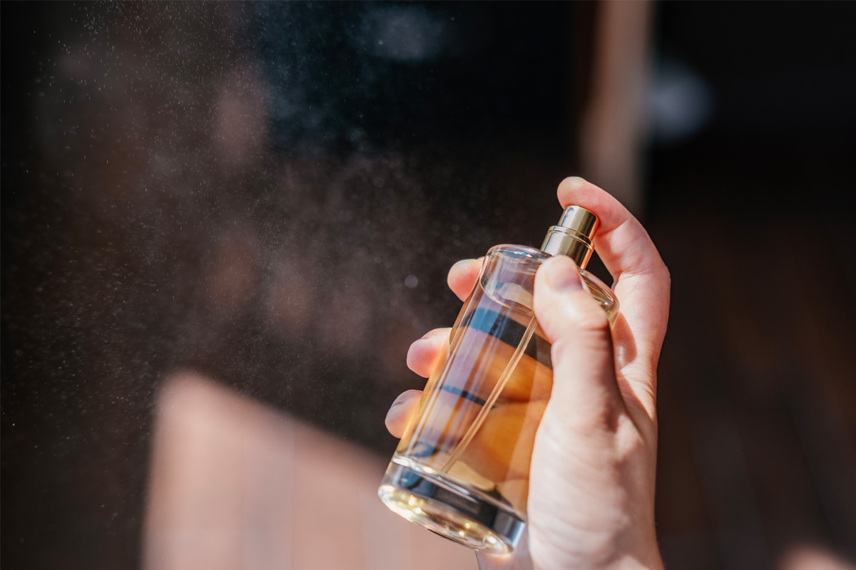 hombre tomando una botella de perfume