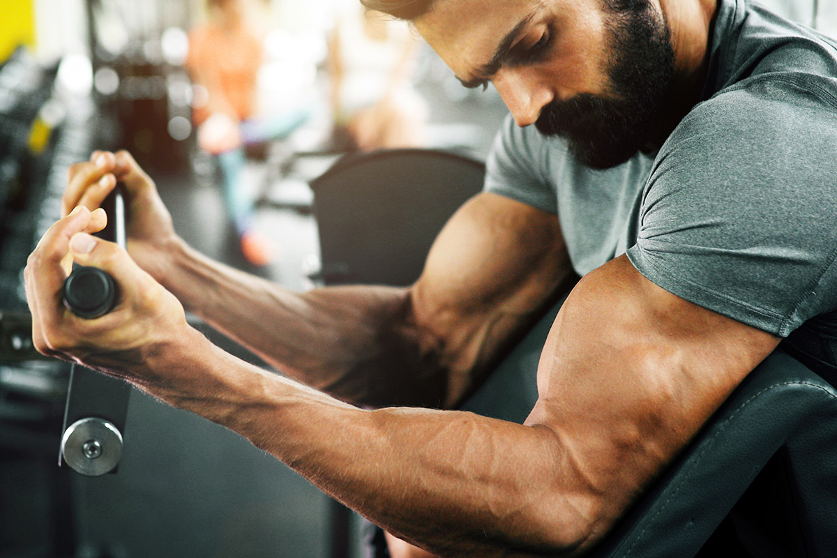 hombre entrenando bíceps en un predicador