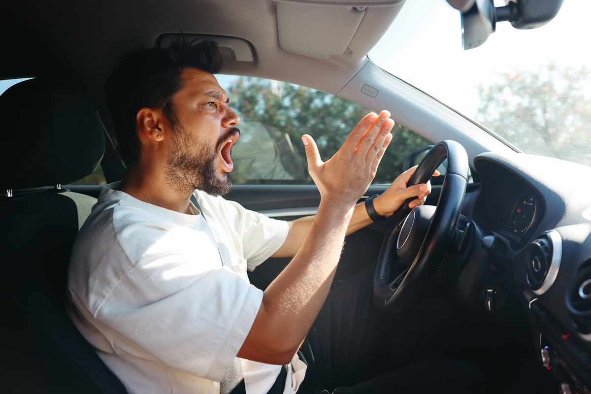 hombre sufriendo de enojo al volante