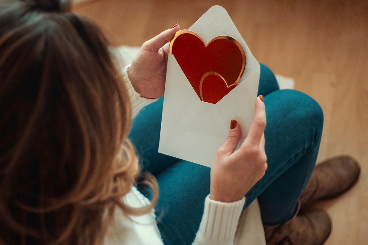 mujer abriendo un regalo del día del amor y la amistad