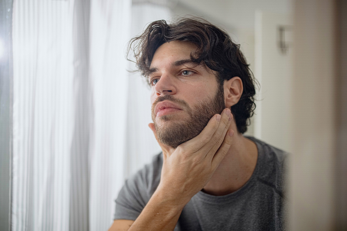 hombre aplicándose aceite en la barba