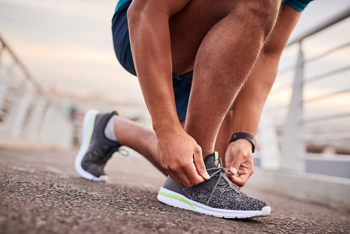 hombre amarrándose los tenis para correr