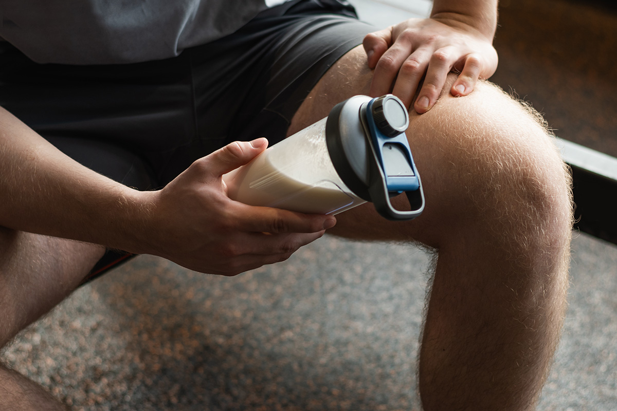 hombre consumiendo licuado de proteína en el gimnasio