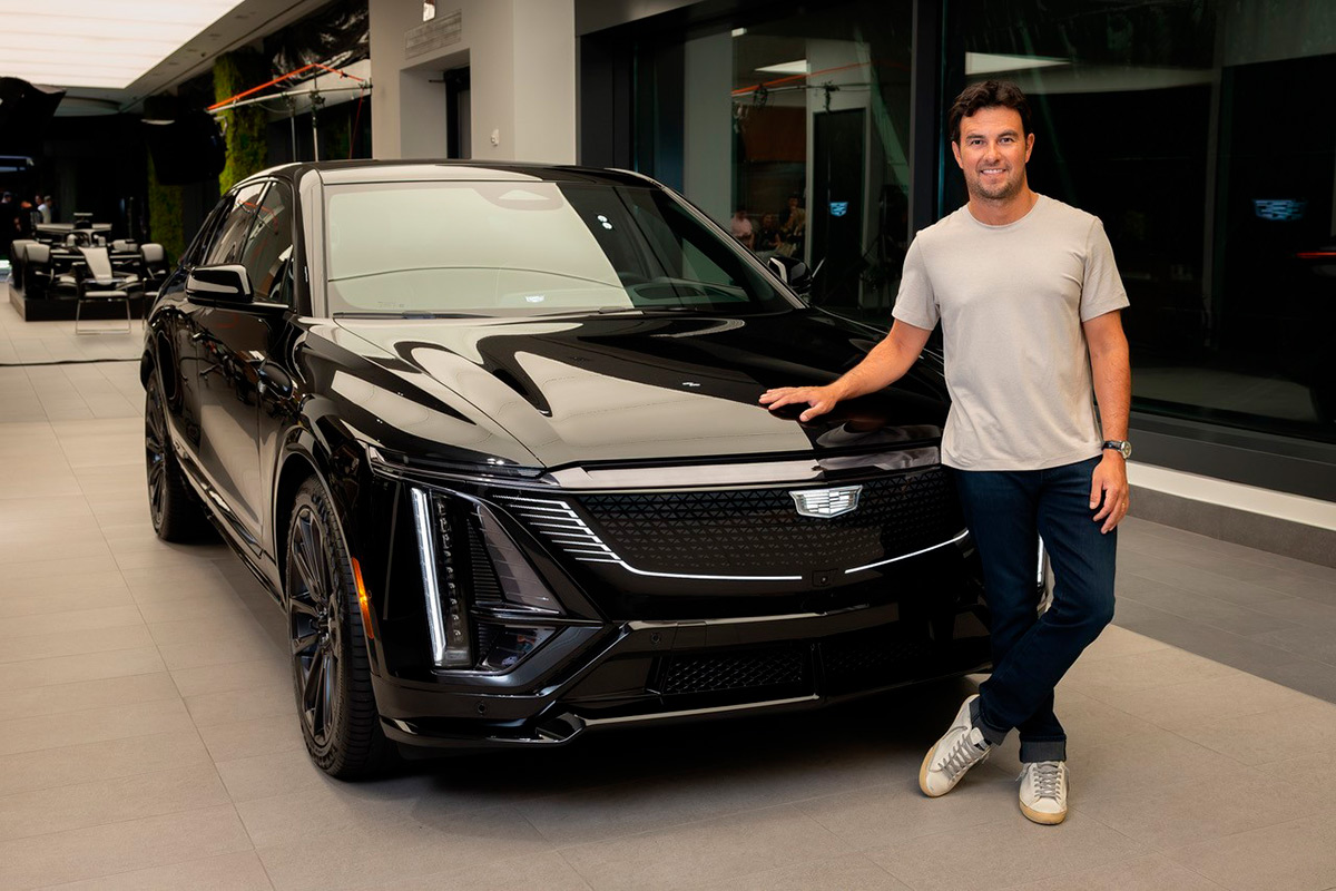checo pérez junto a un auto cadillac