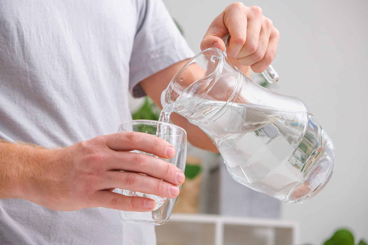 hombre sirviéndose un vaso de agua