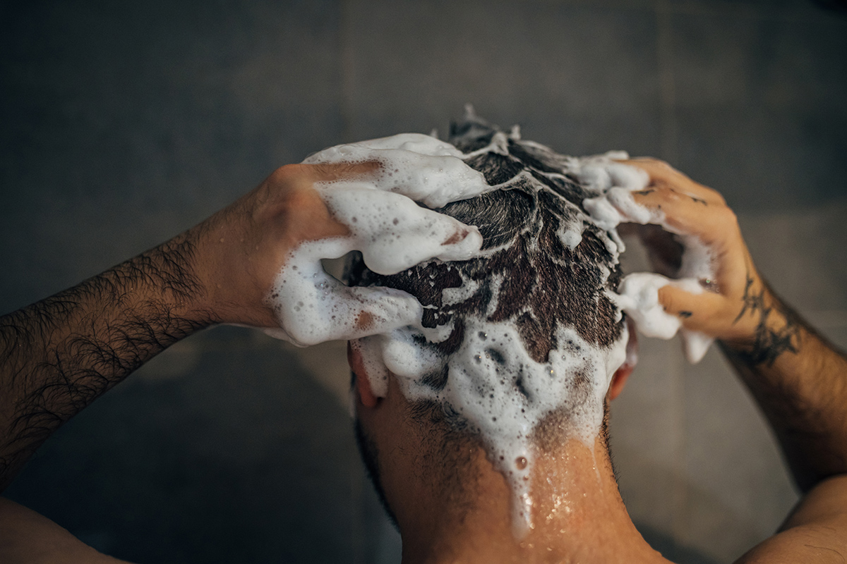 hombre lavándose el cabello