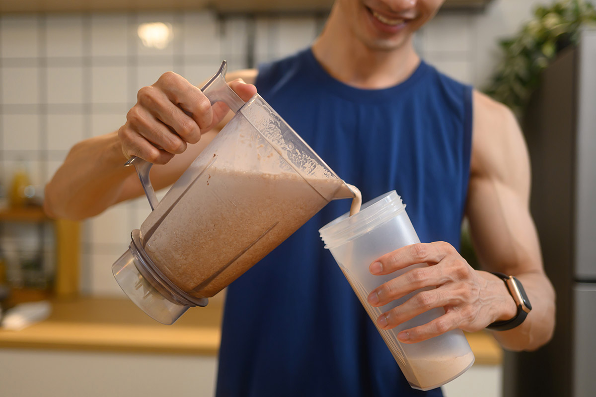 hombre preparándose un licuado de proteína