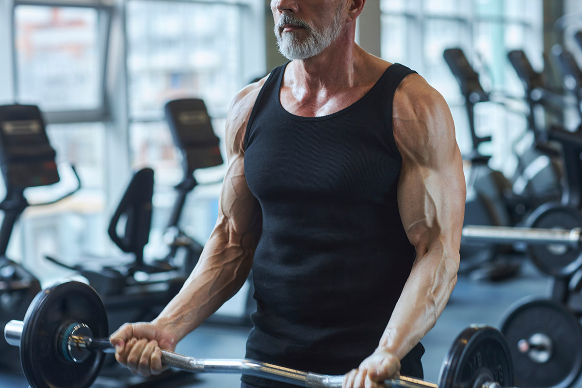 hombre entrenando curl para biceps con barra