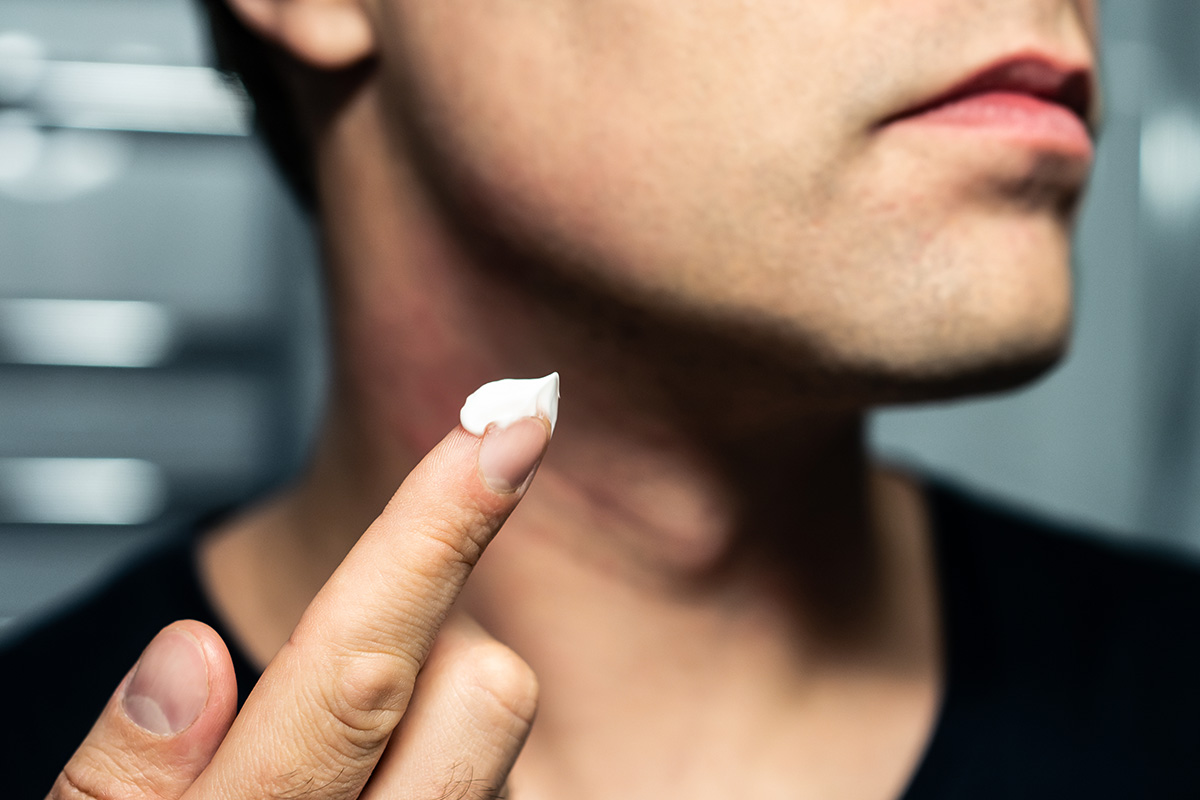 hombre poniéndose crema en la cara