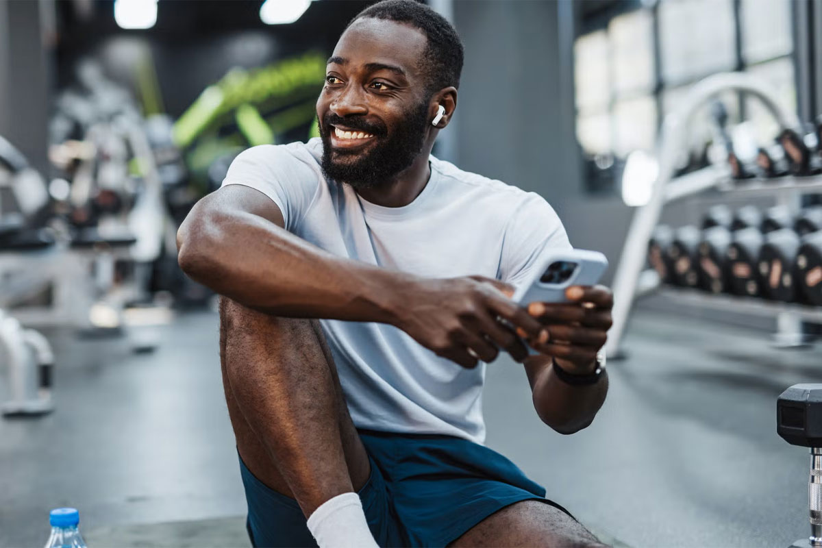 hombre sentado con el celular en la mano