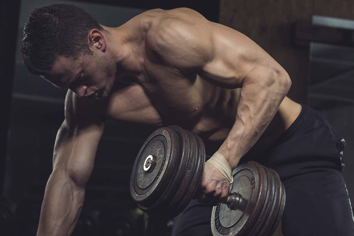 hombre entrenando en el gimnasio con una mancuerna