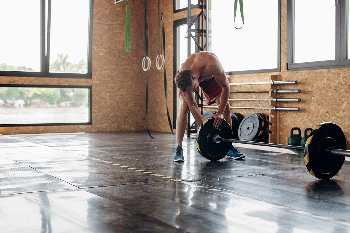 hombre cargando una barra con peso