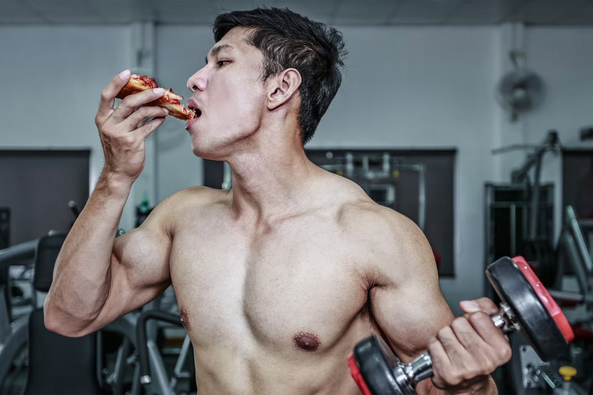 hombre comiendo un pedazo de pizza con una pesa en la mano