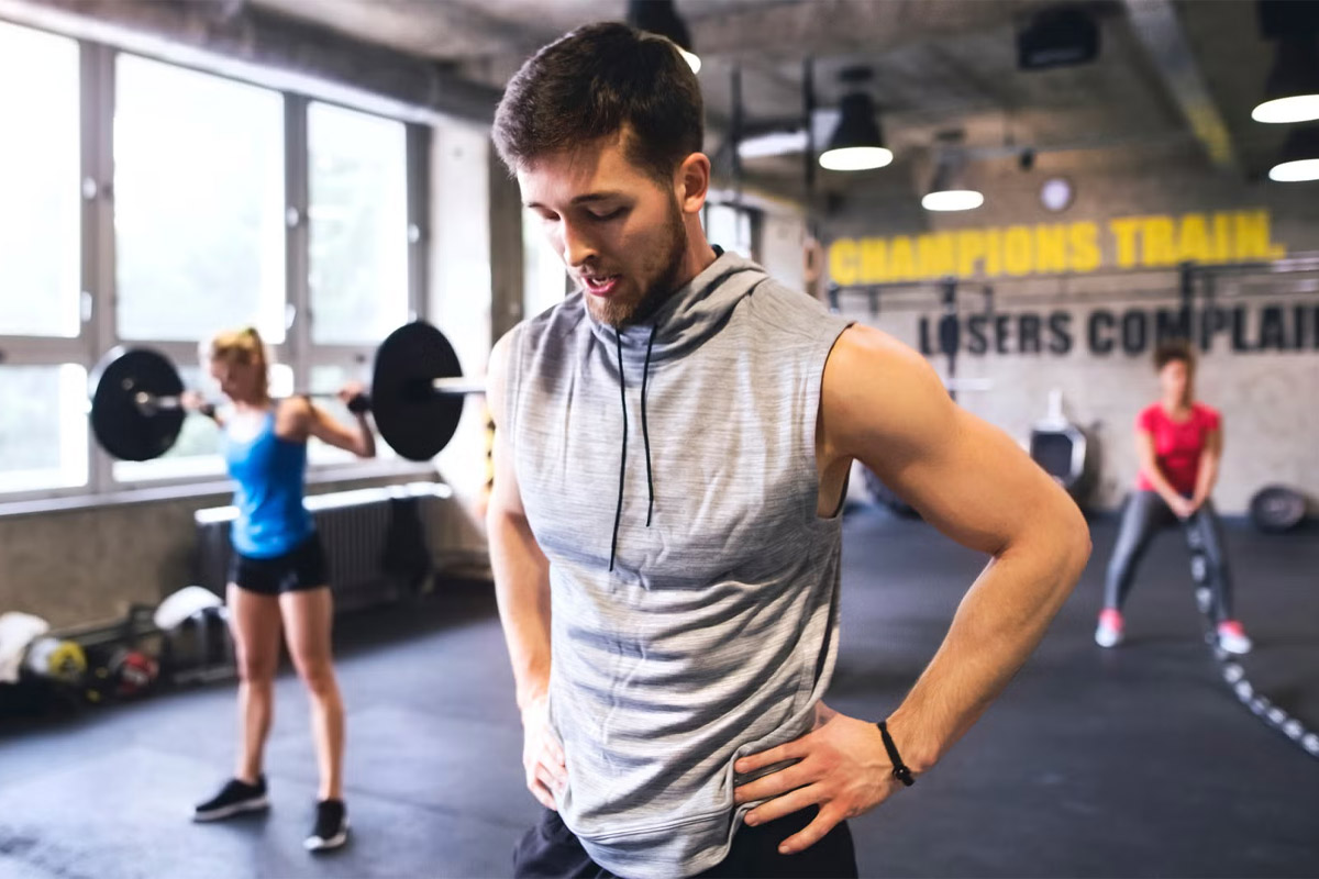 Hombre tomando un descanso de su entrenamiento en el gimnasio