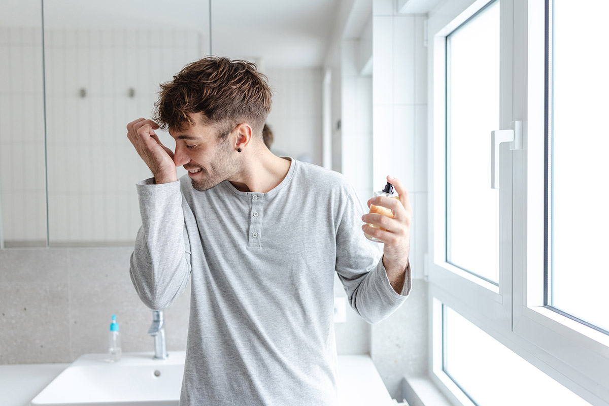 hombre poniéndose perfume