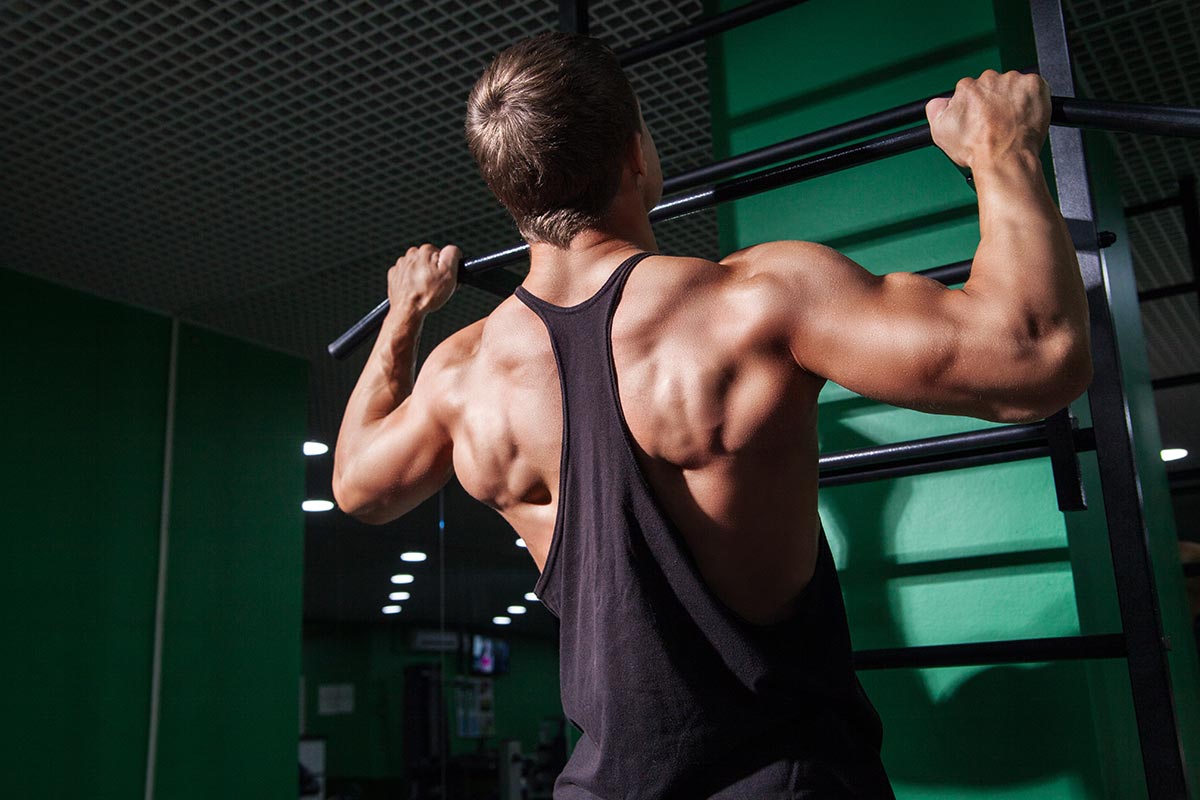 hombre haciendo dominadas en un gimnasio